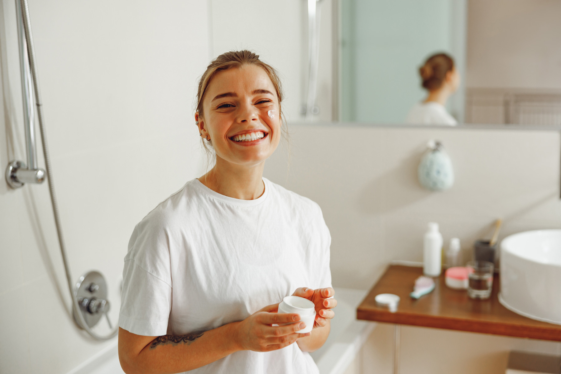 Young woman in a bathroom, considering new bath.